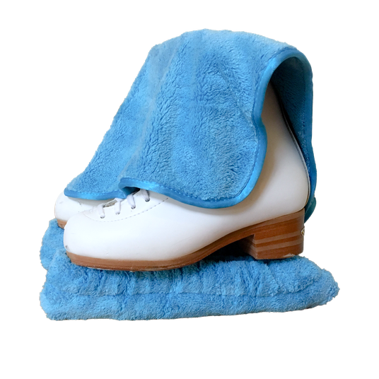 A white figure skate in a royal blue microfiber blade cover